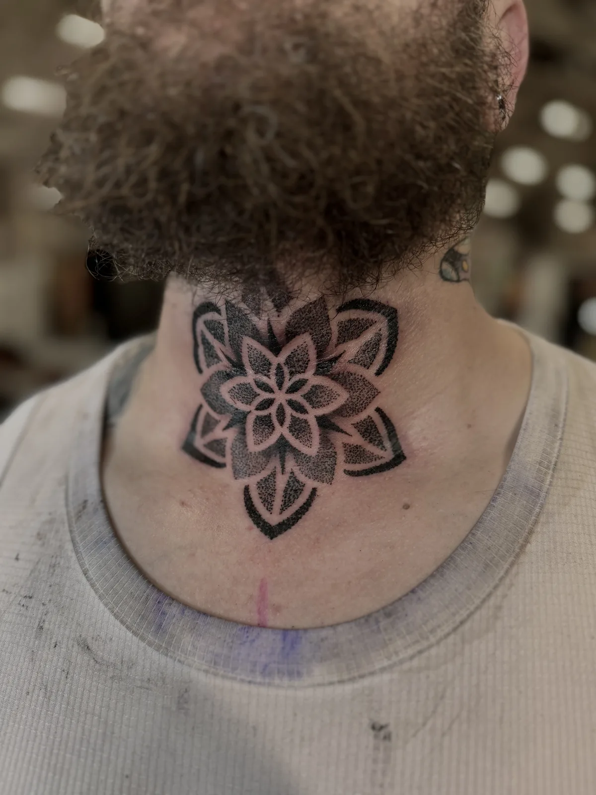 Dotwork mandala tattoo on the front of the throat by Scotty Massa